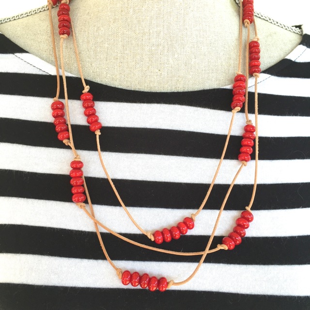 Handmade red glass beads on brown leather